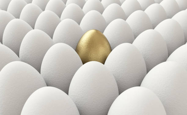 Golden egg standing out stock photo