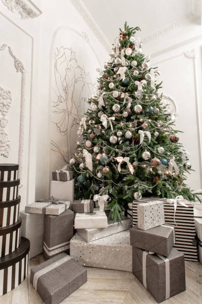istock Presents and Gift boxes under Christmas Tree. Boxes with ribbon bow. New year decorated house interior. Winter Holiday concept. 1076053278