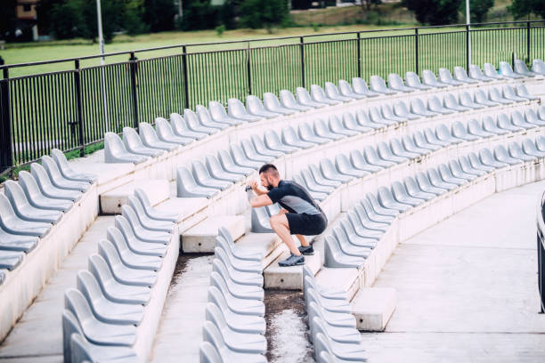 istock Personal trainer working out on stadium stairs, making leg workout 1076058382