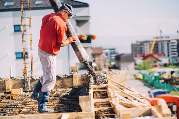 istock Construction details - worker laying cement or concrete with automatic pump at house construction 1076059152
