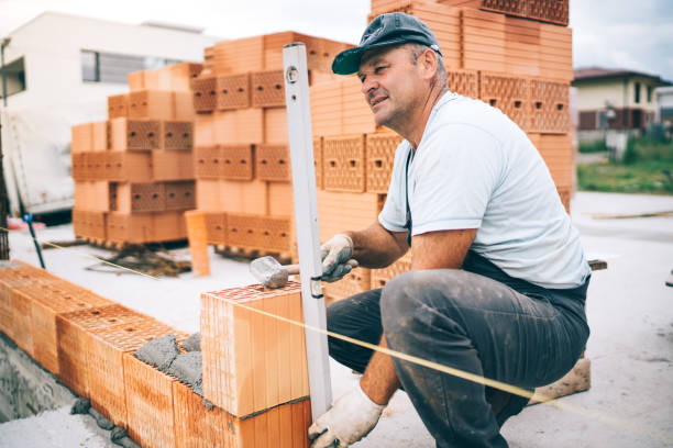 istock professional construction worker laying bricks and building house in industrial site 1076060130