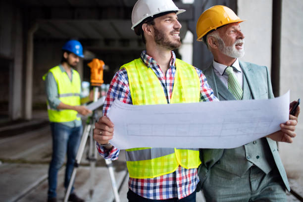 istock Confident team of architects and engineers working together on construction site 1076060460