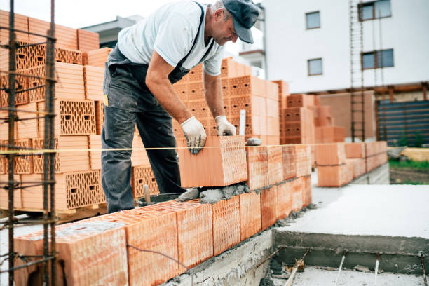 istock worker using pan knife for building brick walls with cement and mortar 1076060566