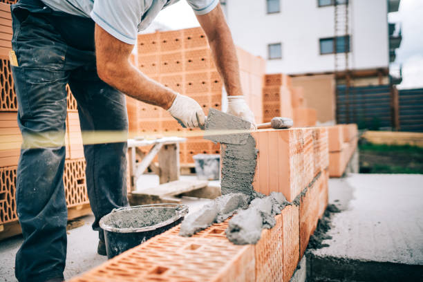 Close up of industrial worker, bricklayer installing bricks on construction site Close up of industrial worker, bricklayer installing bricks on construction site masonry contractor stock pictures, royalty-free photos & images