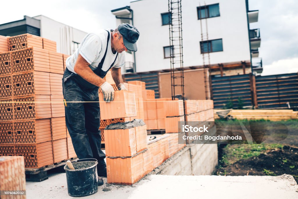 Mason Profession Industrial Mason On Construction Site Working With Bricks And Building ...