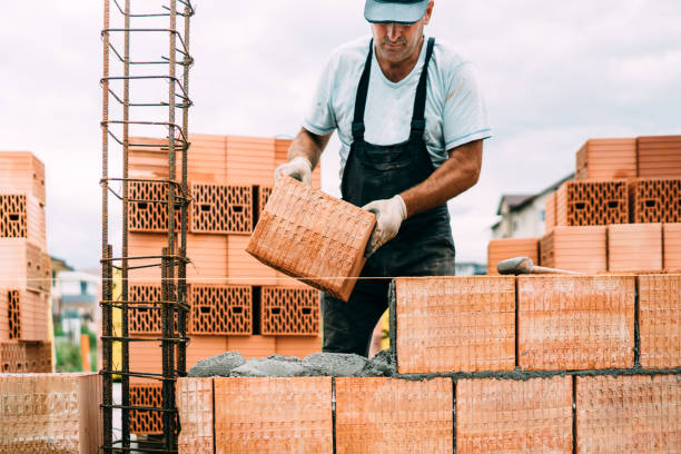 professional, portrait of industrial worker building walls with ceramic bricks stock photo