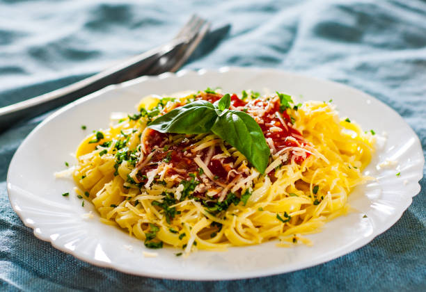 istock Linguine pasta with fresh tomato sauce, grated cheese and basil in white plate 1076068278
