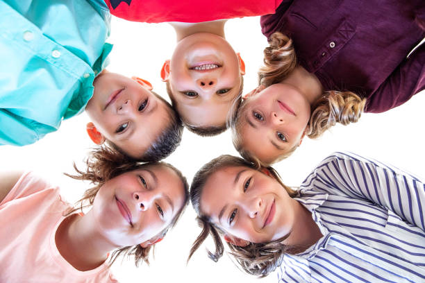 istock Group Of Children of Various Ages Standing in Circle, Looking Down Into Camera. 1076074582