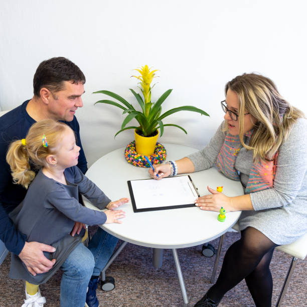 Father and toddler daughter in therapist office during counselling assessment meeting. Father and toddler daughter in therapist office during counselling assessment meeting. todler care stock pictures, royalty-free photos & images