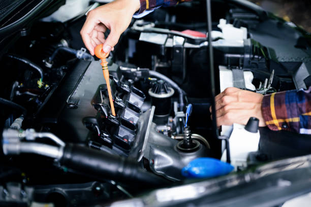 Close up hands checking lube oil level of car engine from deep-stick for service and maintenance concept. stock photo