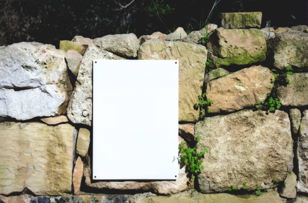 leeres weißes schild auf einer ländlichen steinmauer in der intensivsten - coutryside stock-fotos und bilder