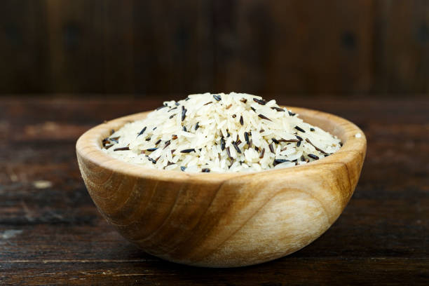 木製の背景に木製の板で白と黒のワイルド ライス。 - carbohydrate rice cereal plant uncultivated ストックフォトと画像