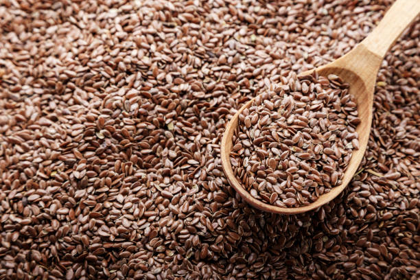 istock flax seeds scattered as a background and poured into a spoon. 1076091806