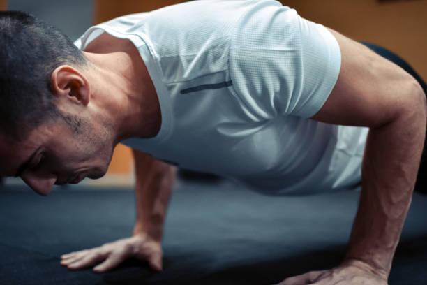 istock view of determined man doing push-ups in gym gym 1076096046