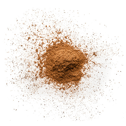 Top view of cinnamon powder heap isolated on white background. Predominant colors are brown and white. High key DSRL studio photo taken with Canon EOS 5D Mk II and Canon EF 100mm f/2.8L Macro IS USM.