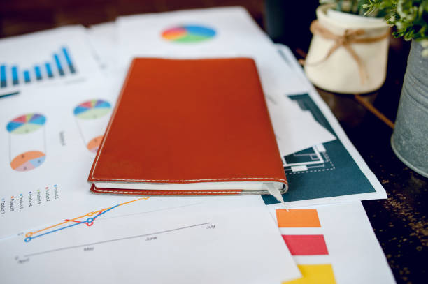 istock A desk with a business notebook, chart and table top. Top view with copy space 1076108136
