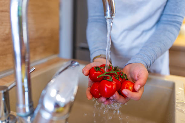 istock Hands woman washing vegetables - tomatoes 1076109898
