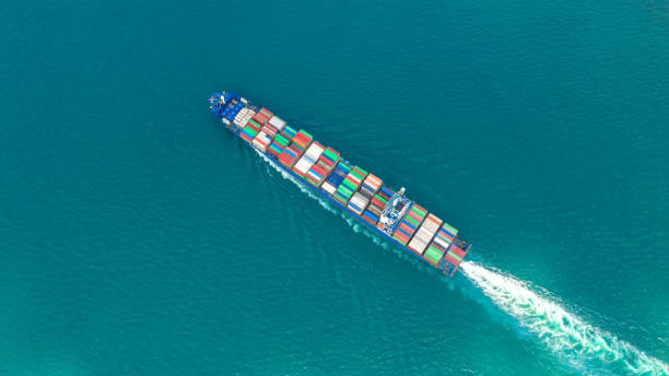 istock Container ship in export and import business and logistics. Shipping cargo to harbor by crane. Water transport International. Aerial view and top view. 1076111732