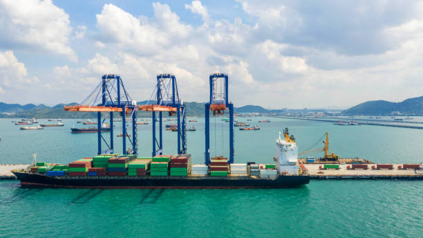 istock Container ship in export and import business and logistics. Shipping cargo to harbor by crane. Water transport International. Aerial view and top view. 1076111748