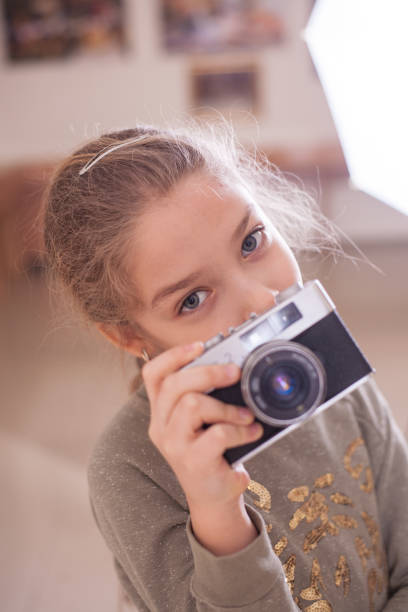 istock Girl with a retro camera makes a photo. 1076115228