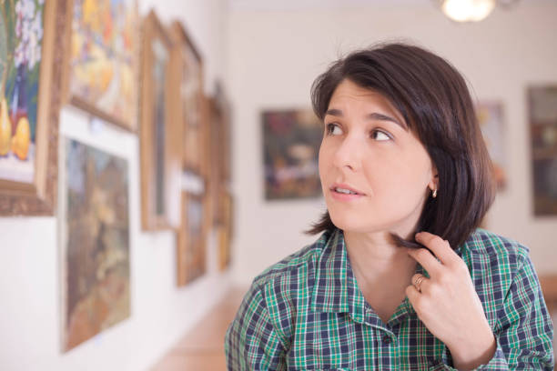 istock A young beautiful woman looking at painting. 1076120542
