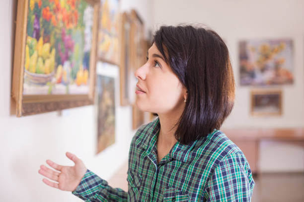 istock A young beautiful woman looking at painting. 1076120558
