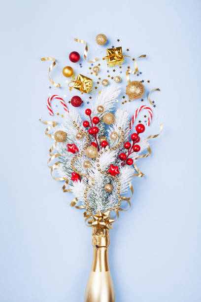 istock Champagne bottle fireworks with confetti, gift and christmas decorations on pastel blue background. 1076126878