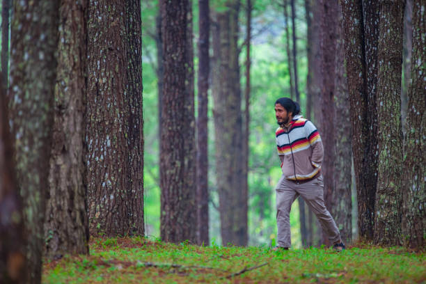 istock Full Length Of Man Walking Amidst Trees In Forest 1076130482