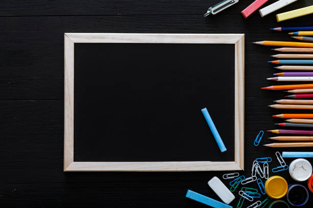 istock Back to school concept, creative workspace with colorful pencils, paints, frame and other school supplies for schoolwork on black desk, time to study, modern primary education, top view, copy space 1076133500