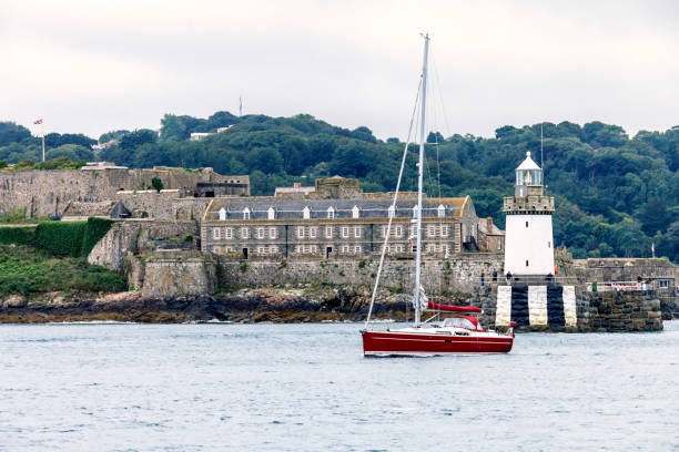Castle Lighthouse and Breakwater at Saint Peter Port As we approach the Island of Guernsey, we see on the port side of our ship the Castle Lighthouse and Breakwater at Saint Peter Port stonewall creek stock pictures, royalty-free photos & images