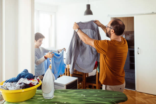 istock Father with his son ironing at home 1076151138