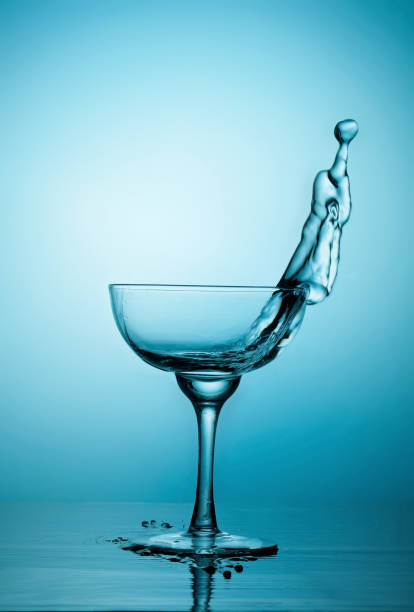 istock Water or alcohol splashes out of a glass 1076157854