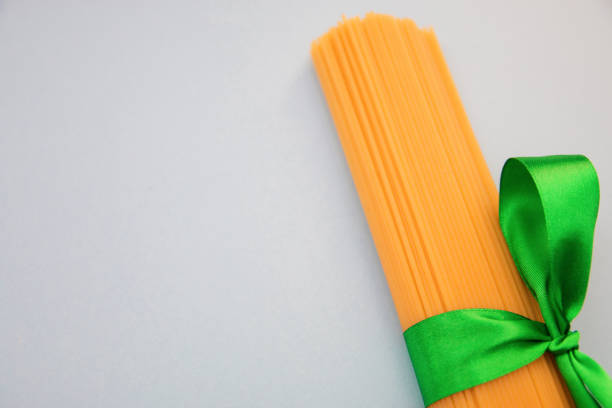 spaghetti tied with a green ribbon on a blue background copy space.