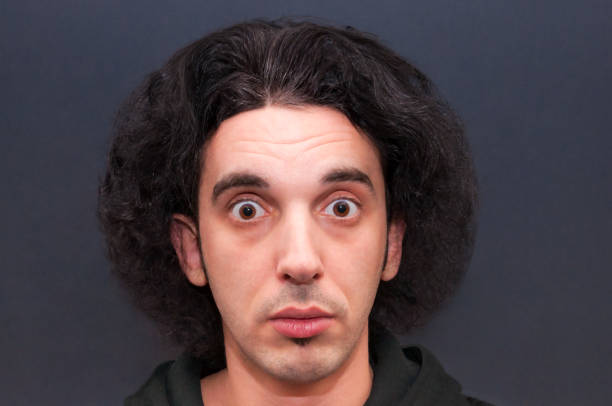 istock Shocked puzzled young man with big opened eyes and fluffy hairstyle 1076172414
