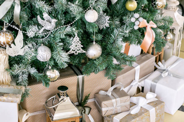 istock Presents and Gift boxes under Christmas Tree. Beige boxes with ribbon bow. New year decorated house interior. Winter Holiday concept. 1076186314