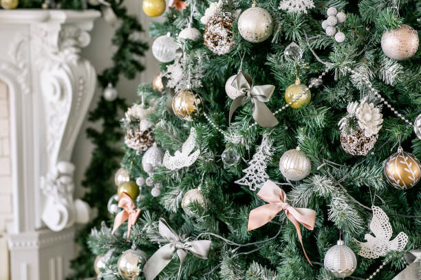 Decorated Christmas tree. Classic apartments with a white fireplace.