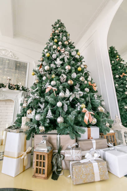 istock Presents and Gift boxes under Christmas Tree. Beige boxes with ribbon bow. New year decorated house interior. Winter Holiday concept. 1076187034