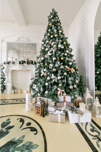 istock Presents and Gift boxes under Christmas Tree. Beige boxes with ribbon bow. New year decorated house interior. Winter Holiday concept. 1076187434
