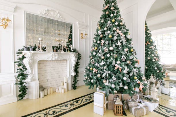 istock Presents and Gift boxes under Christmas Tree. Beige boxes with ribbon bow. New year decorated house interior. Winter Holiday concept. 1076187580