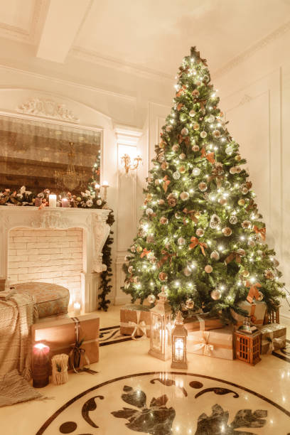 istock classical interior of a white room. Christmas evening by candlelight. classic apartments with a white fireplace, decorated christmas tree, sofa, large windows and chandelier. 1076193714