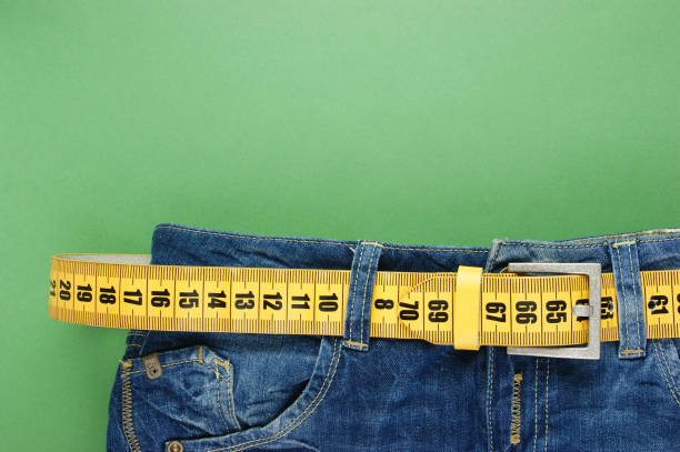 istock jeans with meter belt slimming on the green background 1076200266