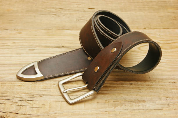 istock leather belt with a buckle on a wooden board 1076200276