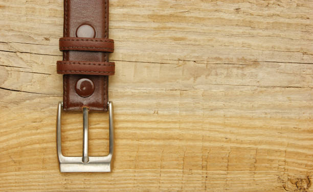 istock leather belt with a buckle on a wooden board 1076200298