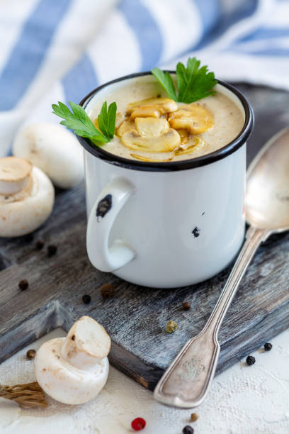 istock Cream-soup with champignons in an enamel mug. 1076202140
