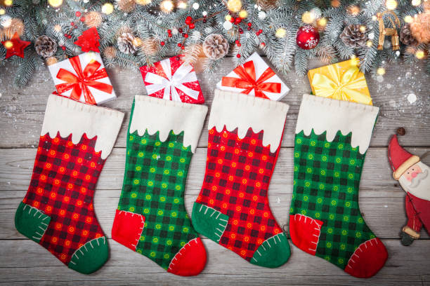 Christmas stocking hanging against wooden wall with gift presents and christmas decorstion stock photo