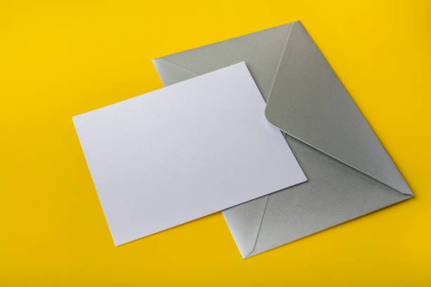 istock Mock-up letter or card with a silver envelope on a yellow background 1076210532