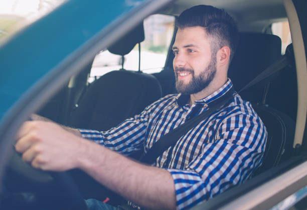 istock Handsome elegant serious man drives a car. 1076212018
