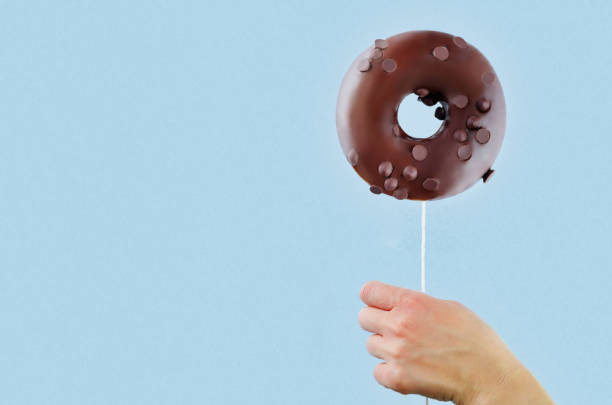 istock Donut in hand on a blue background 1076212064
