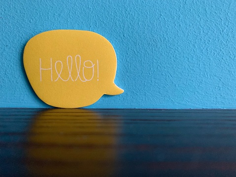 Yellow speech bubble on blue background: Hello!