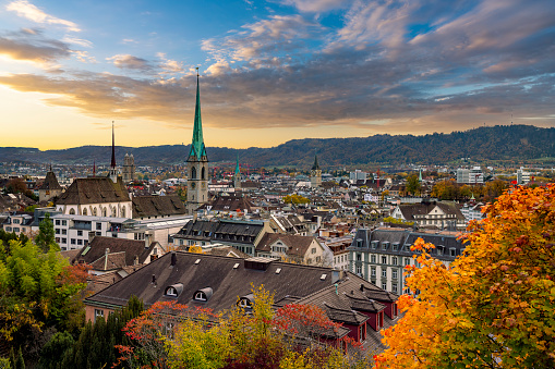Beauitful sunset over Zurich in autumn with Fraumünster church in the centre and mountains in the background